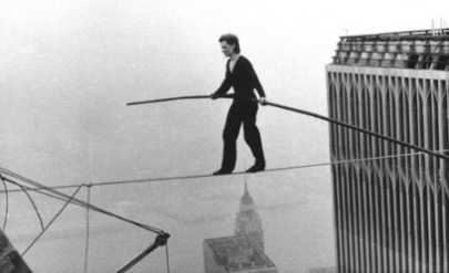 Walking the new product development tightrope between confidence and doubt.  Symbolized by a woman walking a tightrope across a big city skyscape.